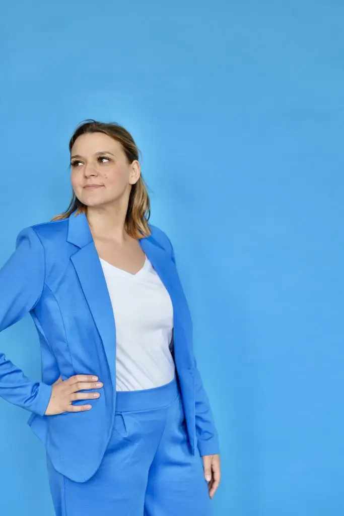Zertifizierte Präventionsmanagerin Nora Remstedt im blauen ANzug vor einer blauen Wand